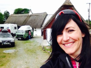 meg in front of thatched cottage